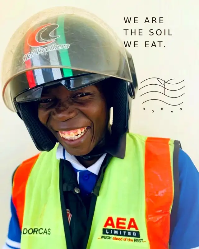 A MOTHERLAND team member in helmet and safety vest, laughing