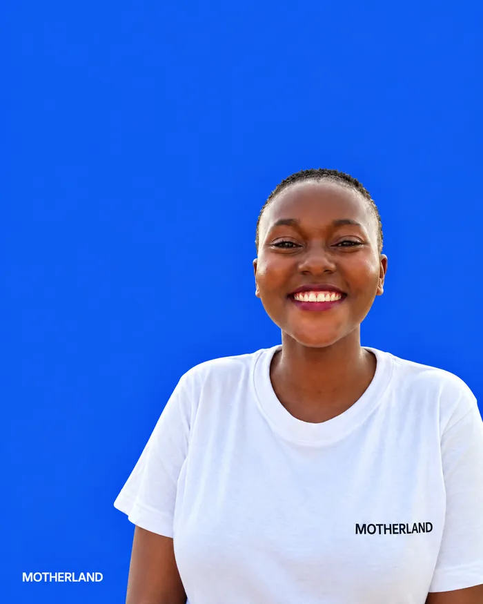 Young woman from Siaya County in a blue T-shirt, laughing